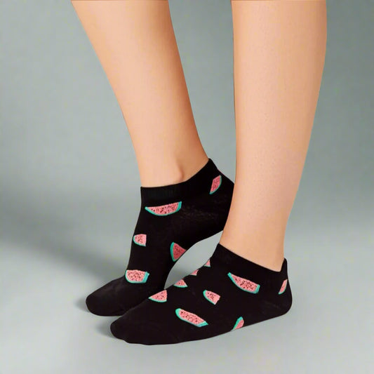 Black socks with watermelon pattern worn by a person on a light background
