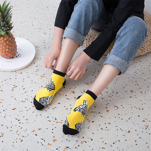 Person wearing yellow socks with zebra pattern on a light-colored floor.