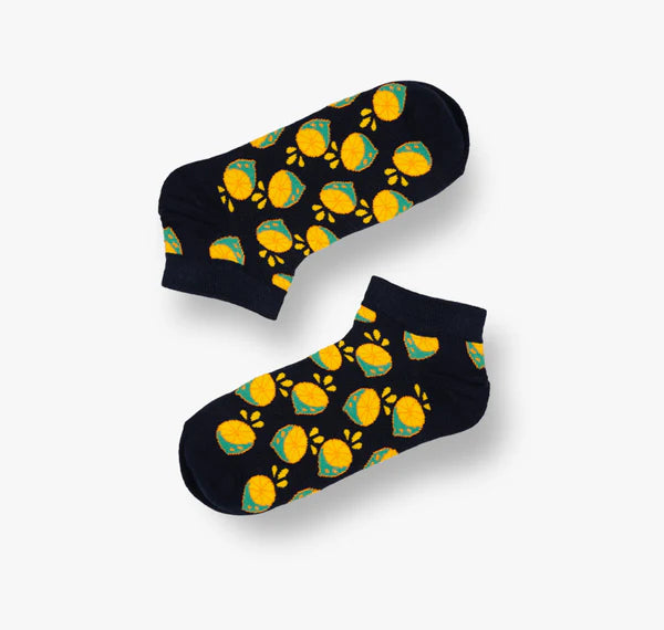 Pair of black socks with yellow and green  lemon pattern on a white background